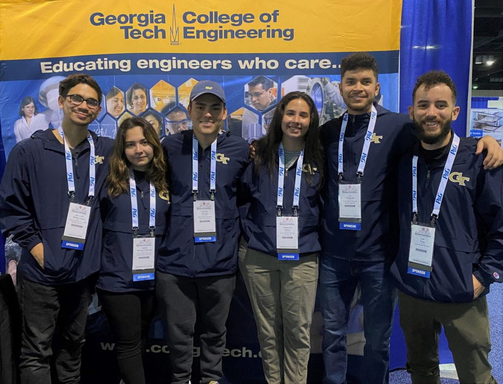 A group of College of Engineering students posing for a group photo in front of a banner.
